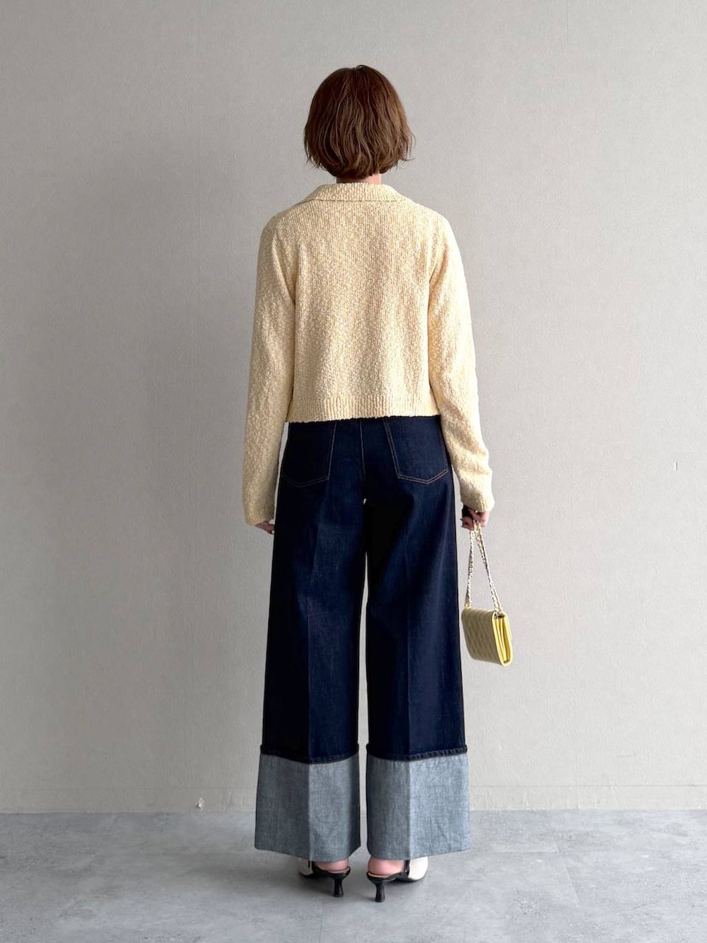 ホワイト系のサンダル、ブラウン系のブルゾン、イエロー系のカーディガン/ボレロを着用したレディースの春コーディネートの7枚目の写真