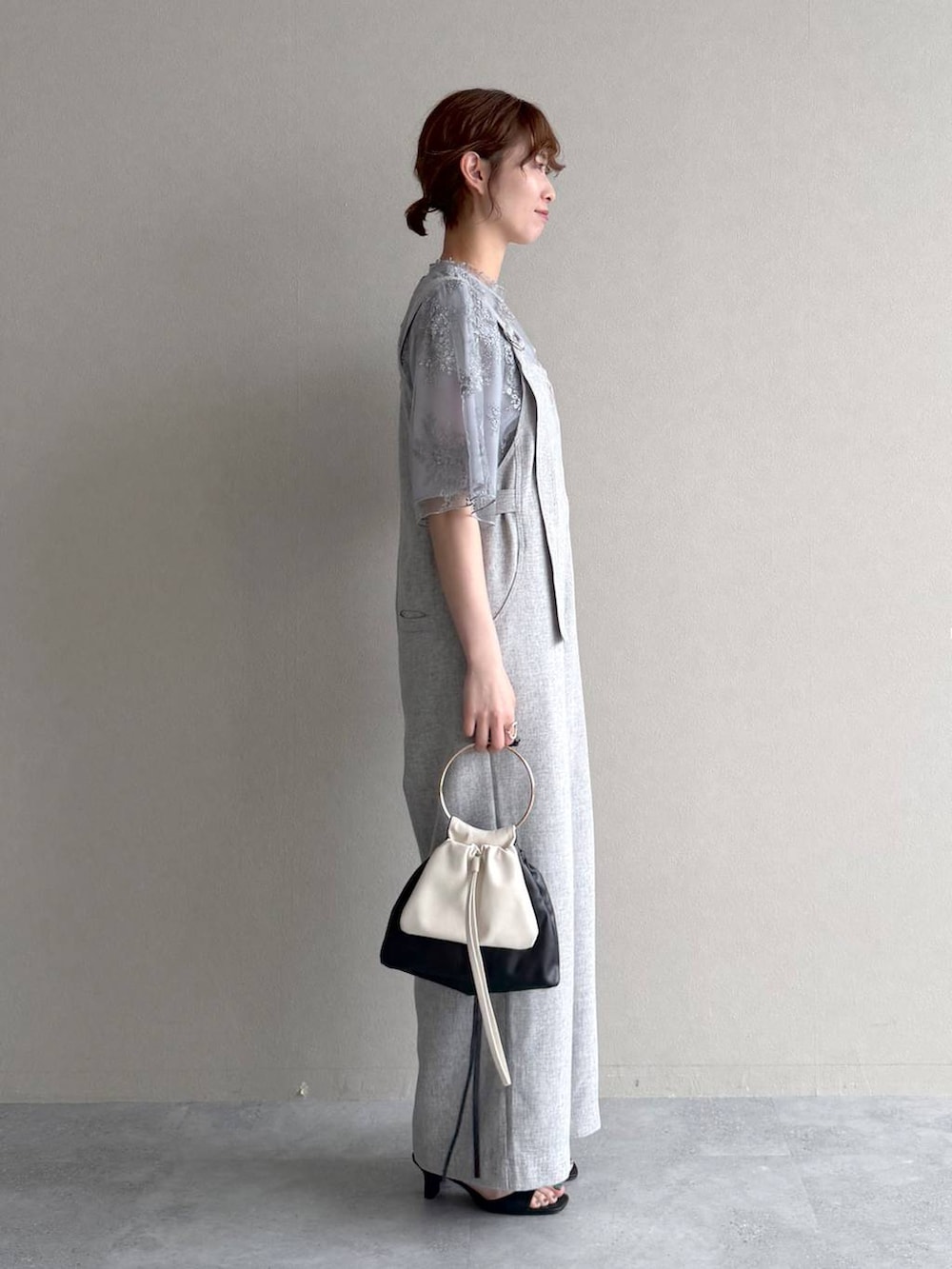 ブルー系のシャツ/ブラウス、ブラック系のハンドバッグ、ブラック系のサンダルを着用したレディースの春コーディネートの2枚目の写真