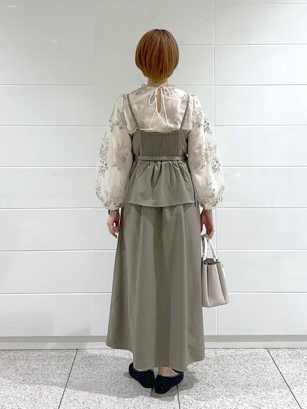 ベージュ系のショルダーバッグ、ブラック系のバレエシューズ、ホワイト系のシャツ/ブラウスを着用したレディースの春コーディネートの3枚目の写真