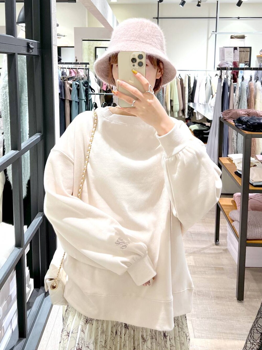 ホワイト系のショルダーバッグ、ブラウン系のブーツ、ベージュ系のスカートを着用したレディースの冬コーディネートの4枚目の写真