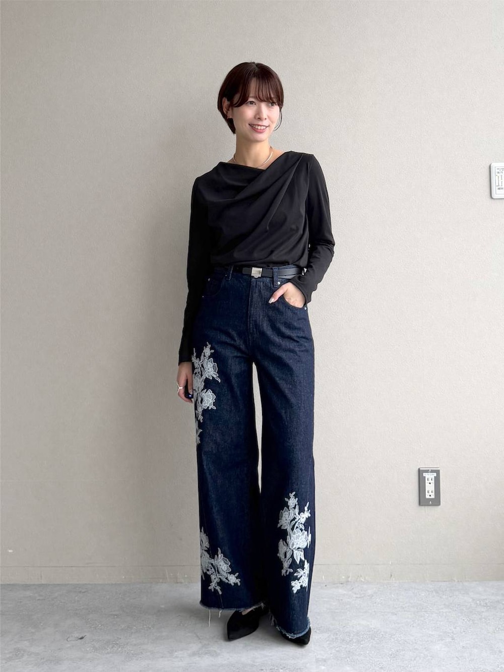 ブラック系のサンダル、ブルー系のデニムパンツ、ブラック系のTシャツ/カットソーを着用したレディースの秋コーディネートの5枚目の写真