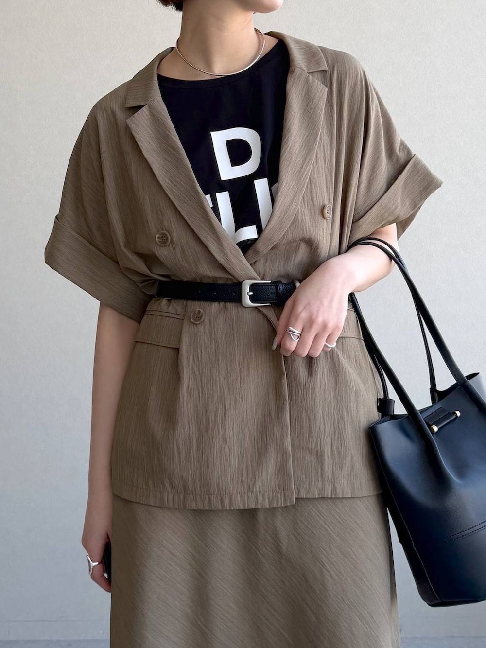 ブラック系のサンダル、ブラック系のTシャツ/カットソー、ブラウン系のスカートを着用したレディースの春コーディネートの4枚目の写真