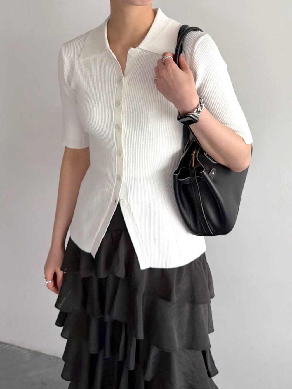 ブラック系のサンダル、ホワイト系のカーディガン/ボレロ、ブラック系のスカートを着用したレディースの春コーディネートの4枚目の写真