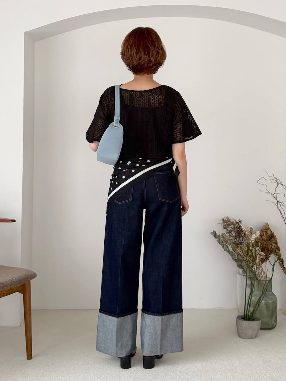 ブラック系のアンサンブル、ブルー系のデニムパンツ、ブラック系のサンダルを着用したレディースの夏コーディネートの3枚目の写真