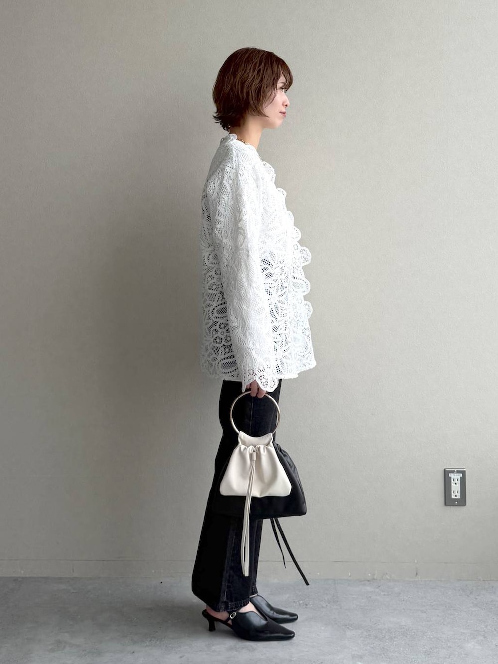 ブラック系のデニムパンツ、ブラック系のサンダル、ブラウン系のブルゾンを着用したレディースの冬コーディネートの6枚目の写真