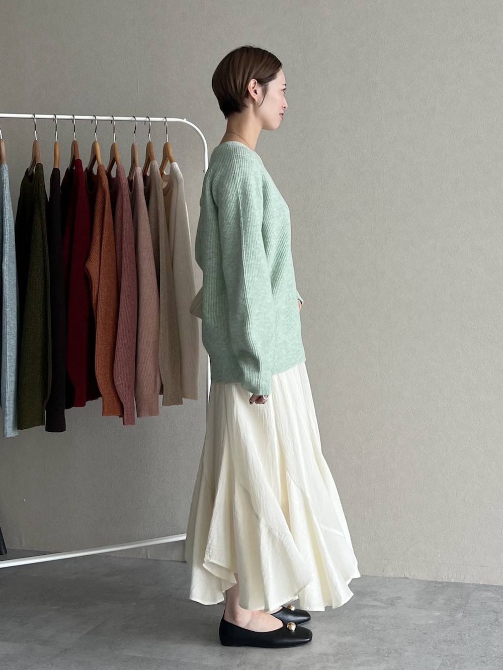 ホワイト系のスカート、ブラック系のブルゾン、ホワイト系のショルダーバッグを着用したレディースの秋コーディネートの5枚目の写真