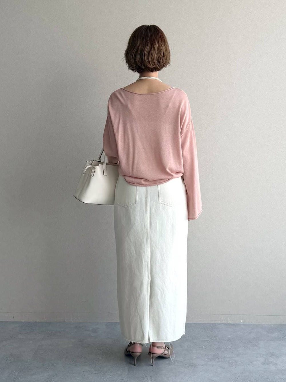 ピンク系のニット/セーター、ブラウン系のサンダル、ホワイト系のスカートを着用したレディースの春コーディネートの3枚目の写真