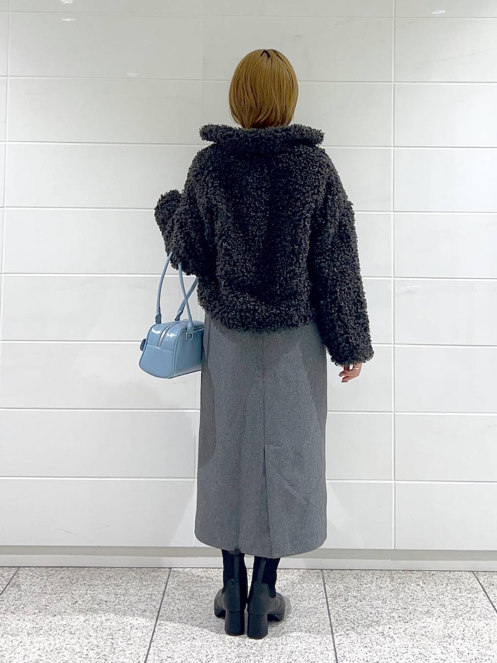 ブラック系のブルゾン、ブラック系のブーツ、グレー系のジャンパースカートを着用したレディースの秋コーディネートの3枚目の写真