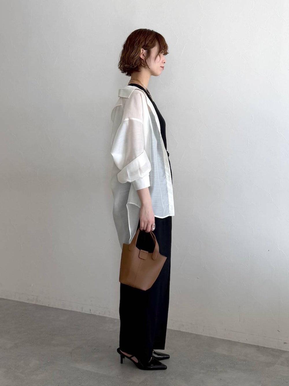 ホワイト系のシャツ/ブラウス、ブラック系のサンダル、ブラック系のタンクトップを着用したレディースの春コーディネートの2枚目の写真