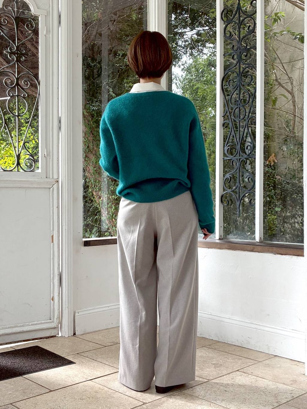 ブラック系のバレエシューズ、グリーン系のニット/セーター、ベージュ系のスラックスを着用したレディースの冬コーディネートの3枚目の写真