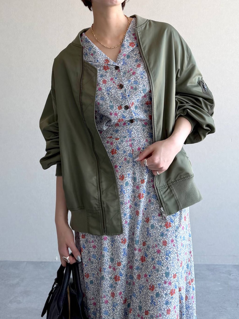 ブラック系のボストンバッグ、ホワイト系のワンピース、グリーン系のMA-1を着用したレディースの冬コーディネートの4枚目の写真