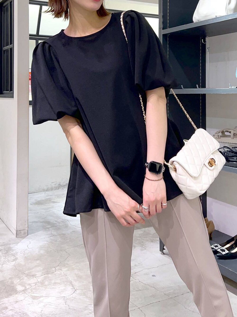 ホワイト系のショルダーバッグ、ブラック系のサンダル、ブラック系のTシャツ/カットソーを着用したレディースの春コーディネートの3枚目の写真