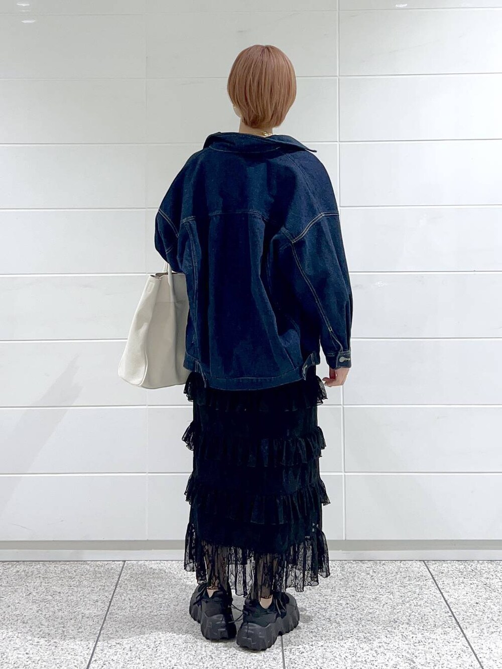 ホワイト系のトートバッグ、ブルー系のデニムジャケット、ブラック系のバレエシューズを着用したレディースの春コーディネートの3枚目の写真