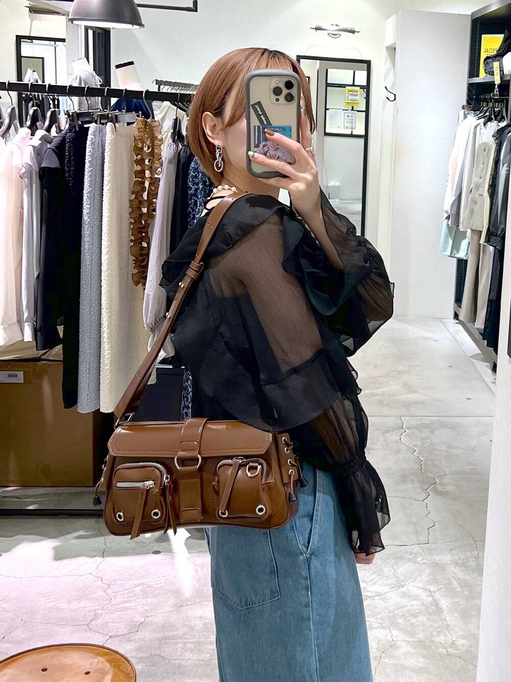 ブラック系のパンプス、ブルー系のデニムパンツ、ブラック系のシャツ/ブラウスを着用したレディースの春コーディネートの6枚目の写真