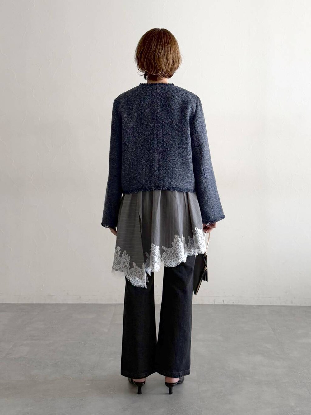 ブラック系のデニムパンツ、ブラック系のサンダル、ブラック系のショルダーバッグを着用したレディースの春コーディネートの3枚目の写真