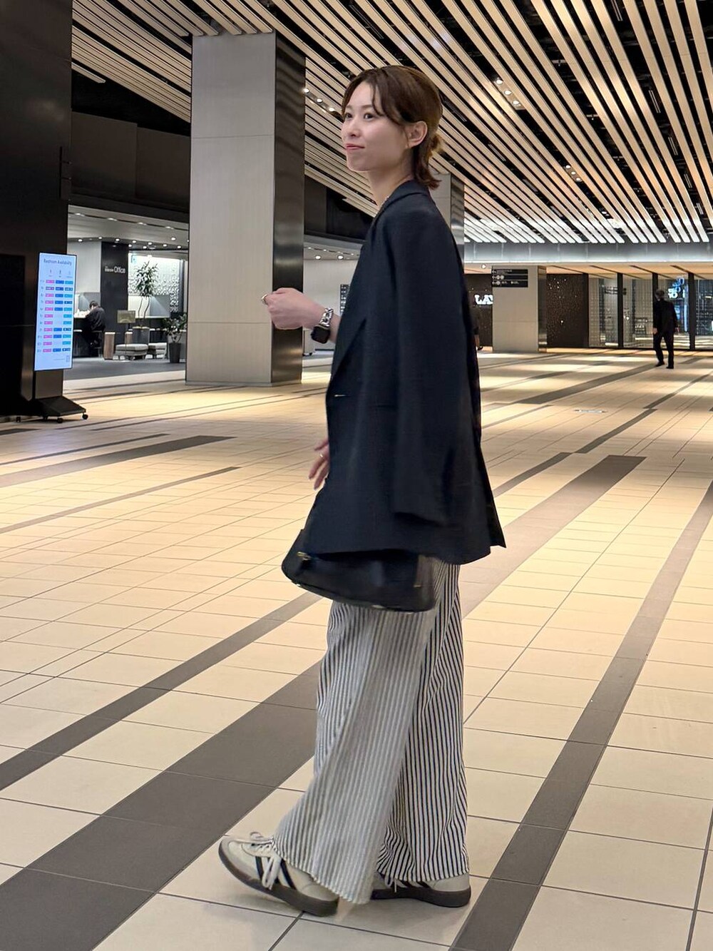 ブラック系のハンドバッグ、ブルー系のその他パンツ、ブルー系のテーラードジャケットを着用したレディースの春コーディネートの4枚目の写真