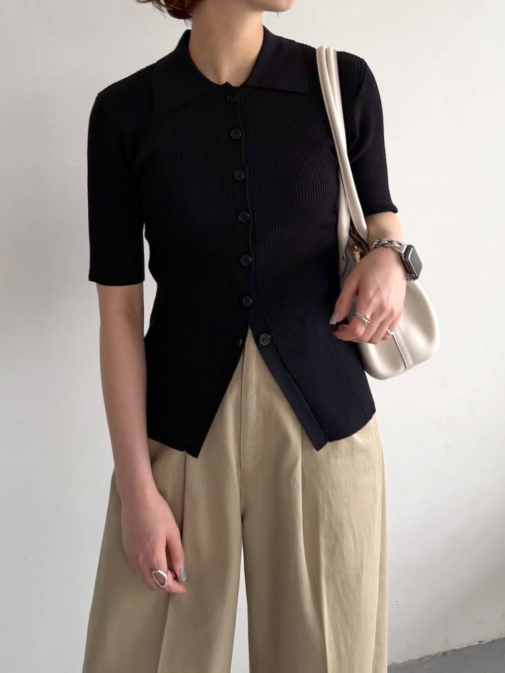 ブラック系のカーディガン/ボレロ、ベージュ系のチノパンツ、ホワイト系のショルダーバッグを着用したレディースの春コーディネートの6枚目の写真