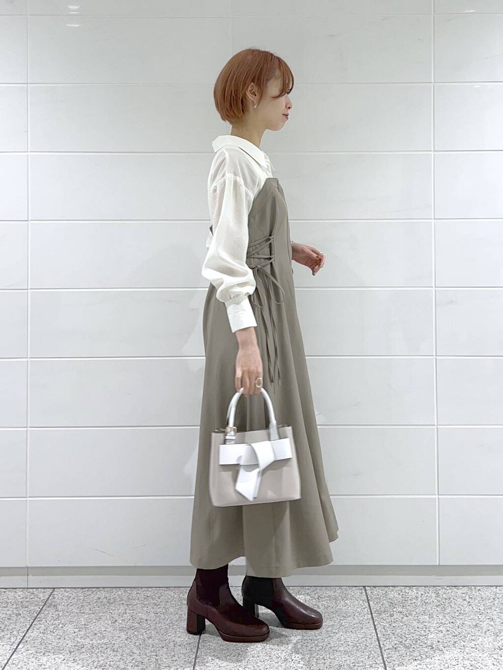 ベージュ系のショルダーバッグ、ホワイト系のタンクトップ、ブラウン系のワンピースを着用したレディースの春コーディネートの2枚目の写真