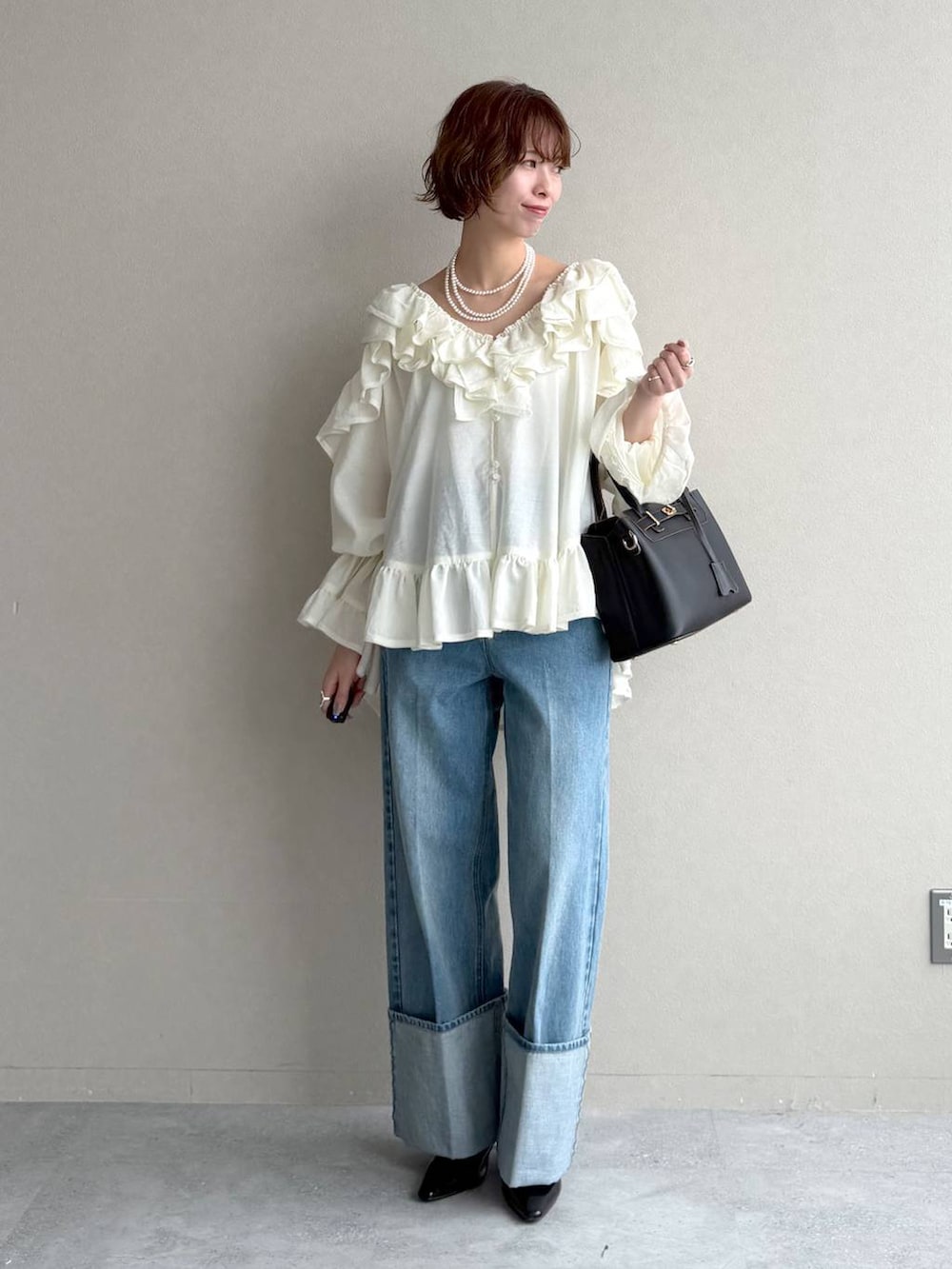 ブラック系のサンダル、ベージュ系のトレンチコート、ブルー系のデニムパンツを着用したレディースの春コーディネートの4枚目の写真