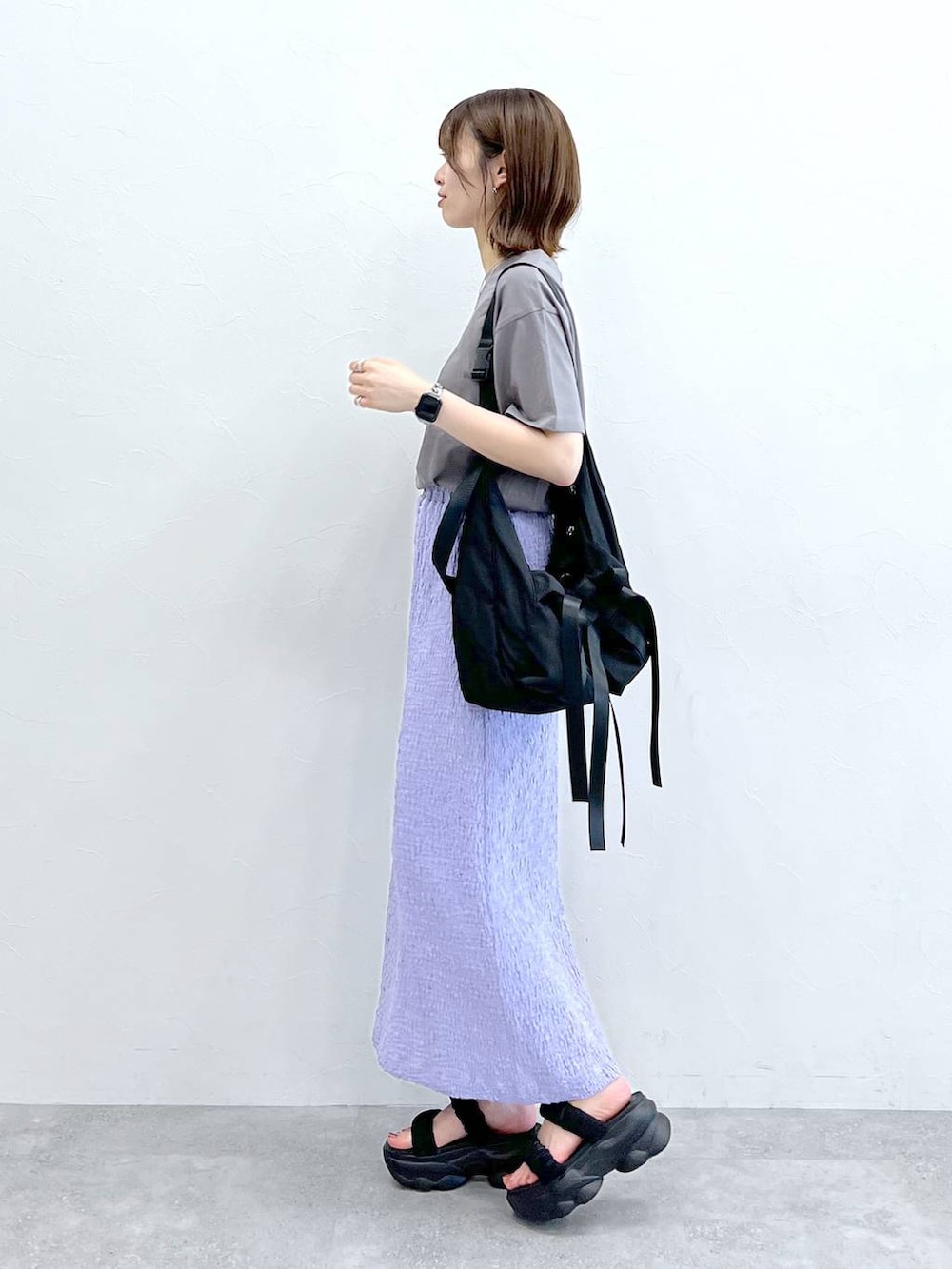 グレー系のTシャツ/カットソー、ブラック系のショルダーバッグ、ブラック系のサンダルを着用したレディースの春コーディネートの2枚目の写真