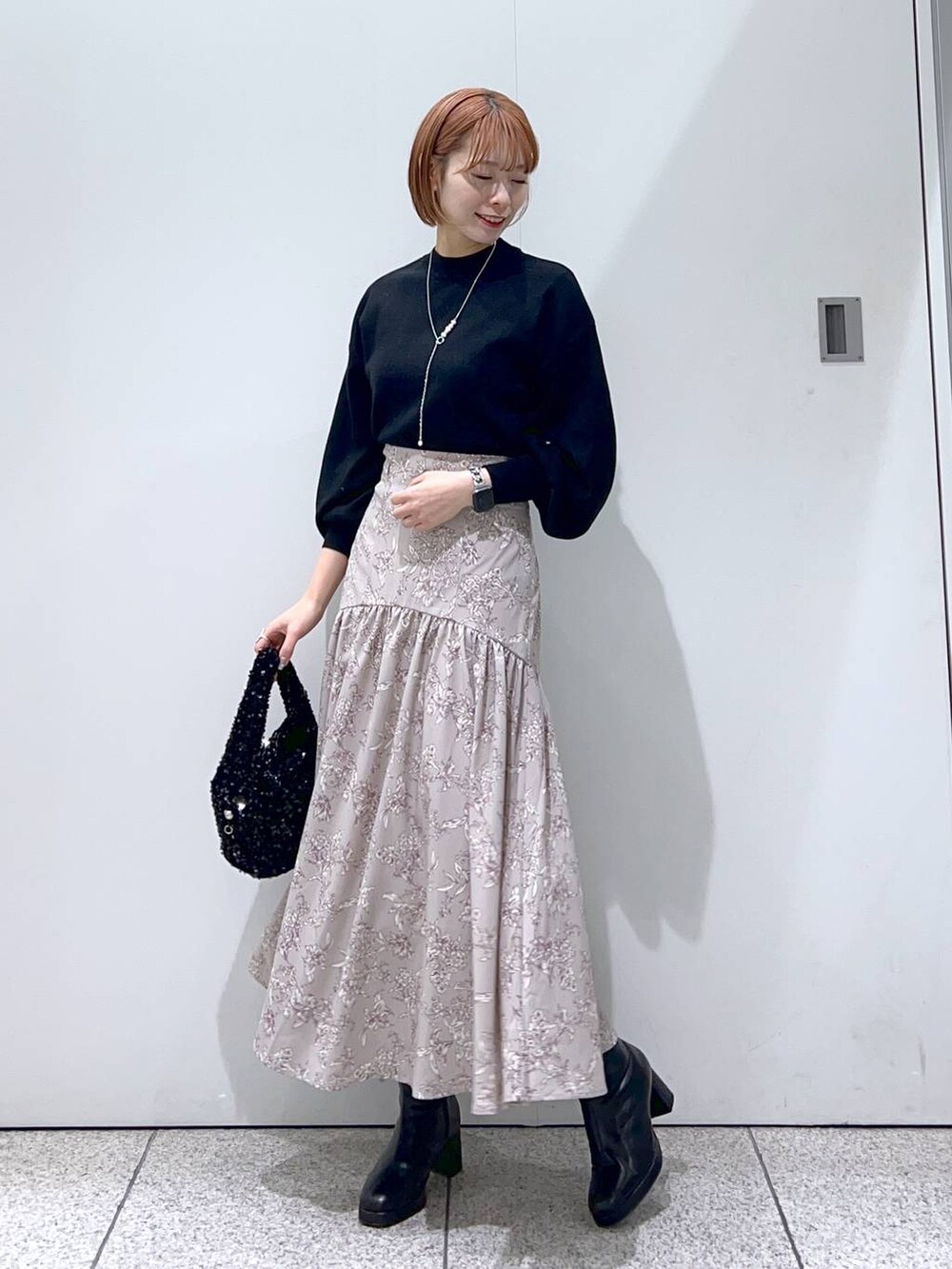 ブラック系のブーツ、ブラック系のニット/セーター、ブラック系のハンドバッグを着用したレディースの冬コーディネートの4枚目の写真