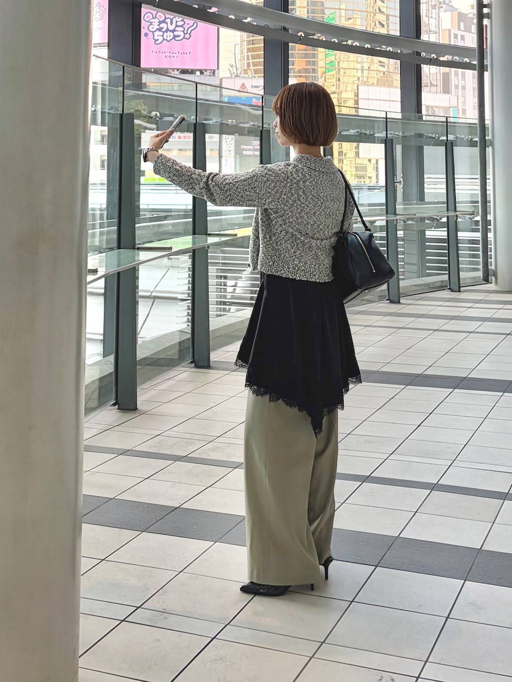 ブラック系のハンドバッグ、ブラック系のサンダル、ブラック系のキャミソールを着用したレディースの春コーディネートの8枚目の写真