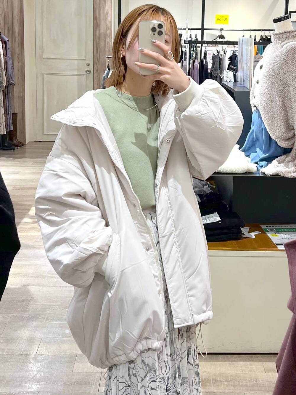 ホワイト系のブルゾン、ホワイト系のボストンバッグ、ブラック系のブーツを着用したレディースの秋コーディネートの7枚目の写真