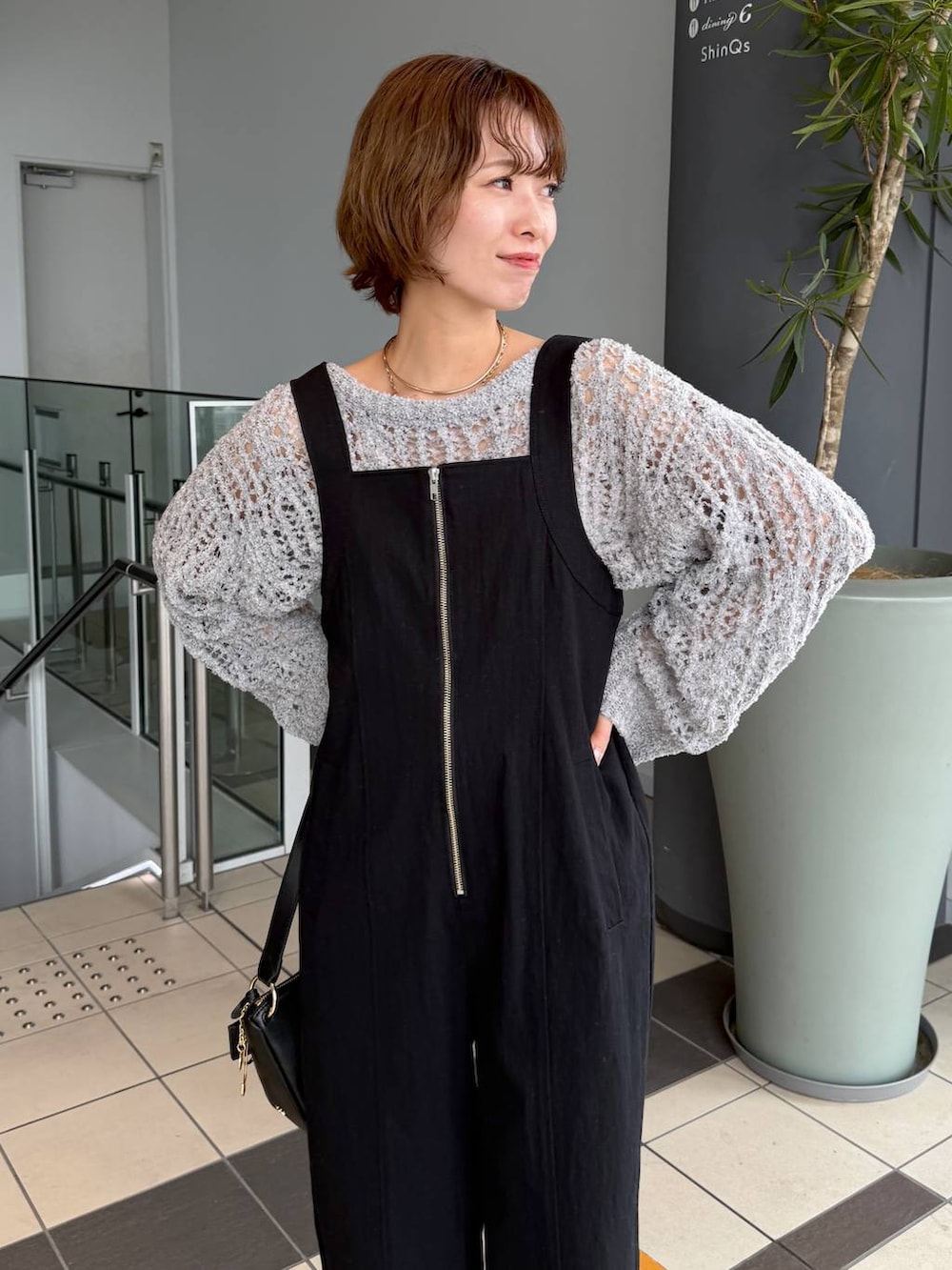 グレー系のニット/セーター、ブラック系のサンダル、ブラック系のショルダーバッグを着用したレディースの春コーディネートの4枚目の写真