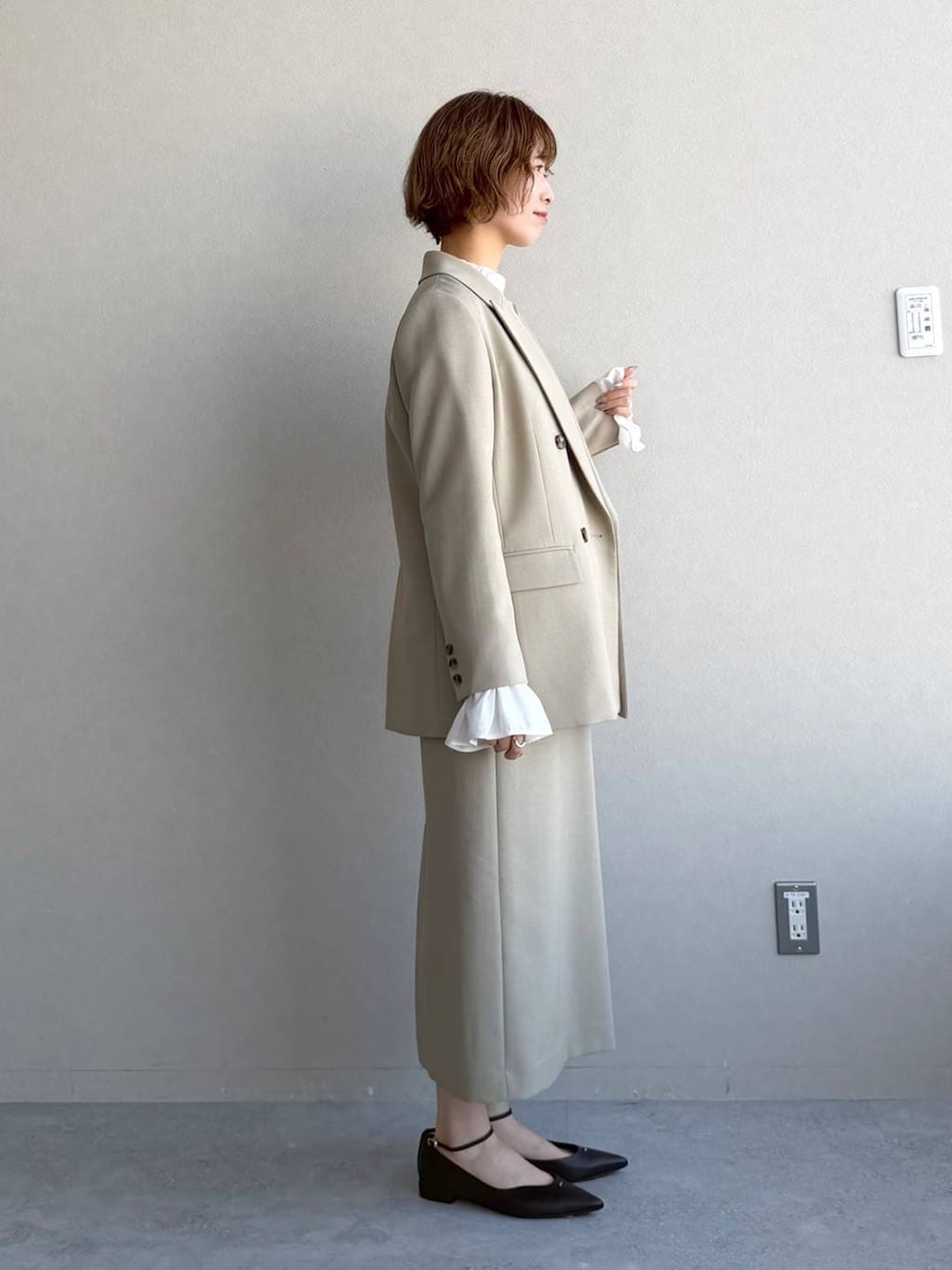 ベージュ系のテーラードジャケット、ベージュ系のワンピース、ホワイト系のシャツ/ブラウスを着用したレディースの冬コーディネートの2枚目の写真