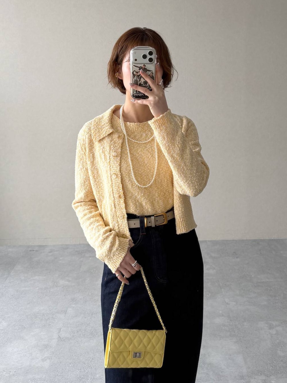 ホワイト系のサンダル、ブラウン系のブルゾン、イエロー系のカーディガン/ボレロを着用したレディースの春コーディネートの8枚目の写真