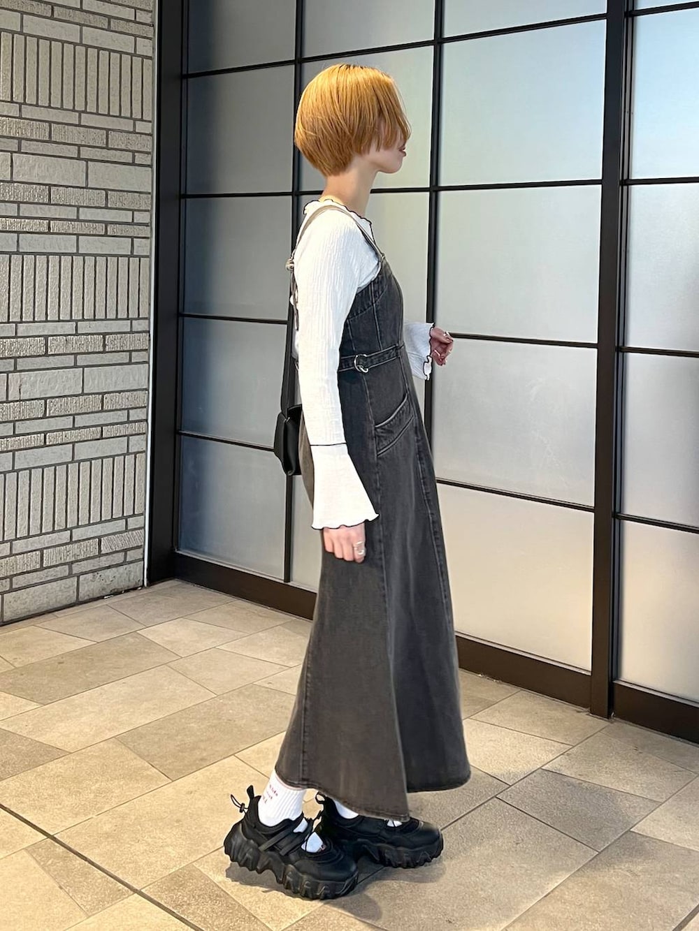 ブラック系のデニムジャケット、ブラック系のジャンパースカート、ブラック系のバレエシューズを着用したレディースの冬コーディネートの5枚目の写真