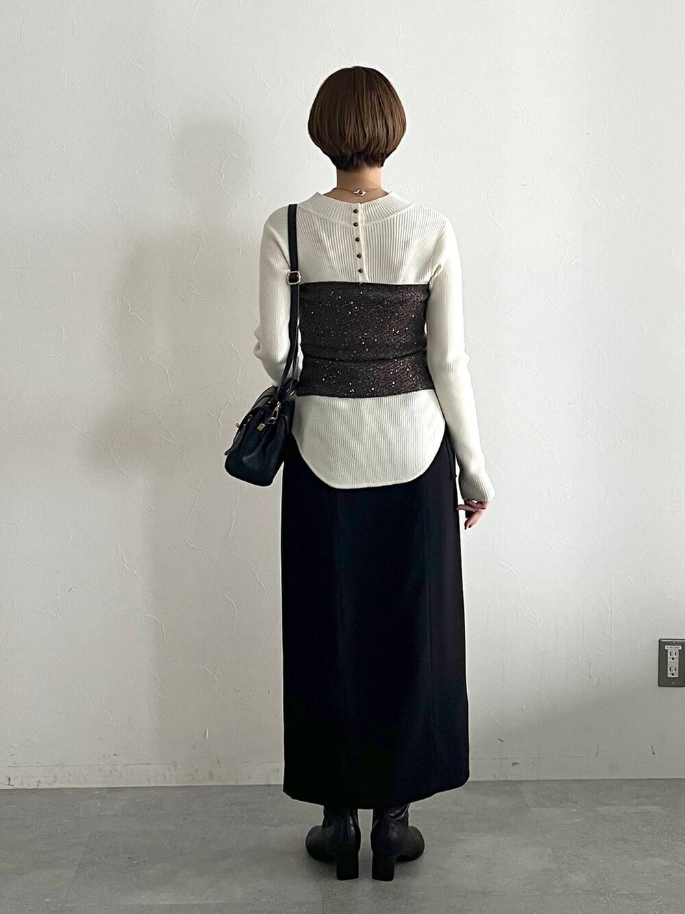 ホワイト系のニット/セーター、ブラック系のブーツ、ブラック系のスカートを着用したレディースの冬コーディネートの3枚目の写真