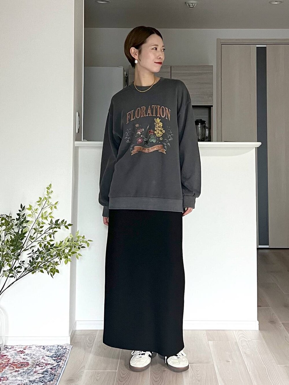 ブラウン系のボストンバッグ、ブラック系のスカート、ベージュ系のネックレスを着用したレディースの秋コーディネートの5枚目の写真