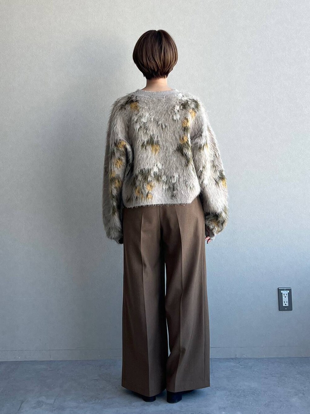 ベージュ系のニット/セーター、ブラック系のブーツ、ブラウン系のスラックスを着用したレディースの冬コーディネートの3枚目の写真