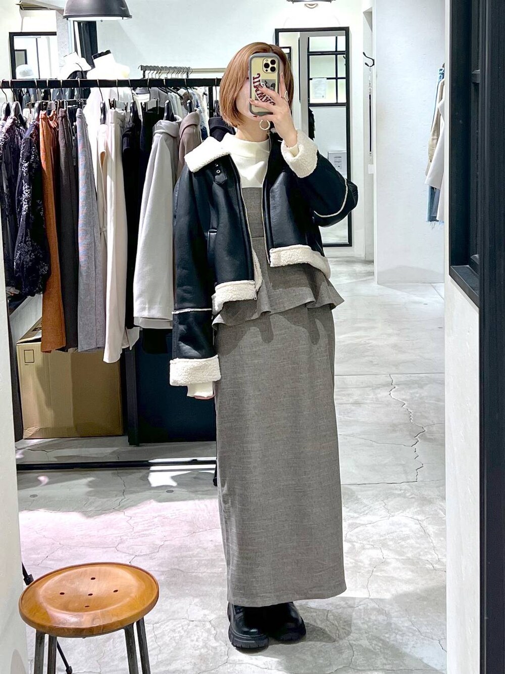 ブラック系のショルダーバッグ、ブラック系のブーツ、ブラウン系のワンピースを着用したレディースの秋コーディネートの7枚目の写真