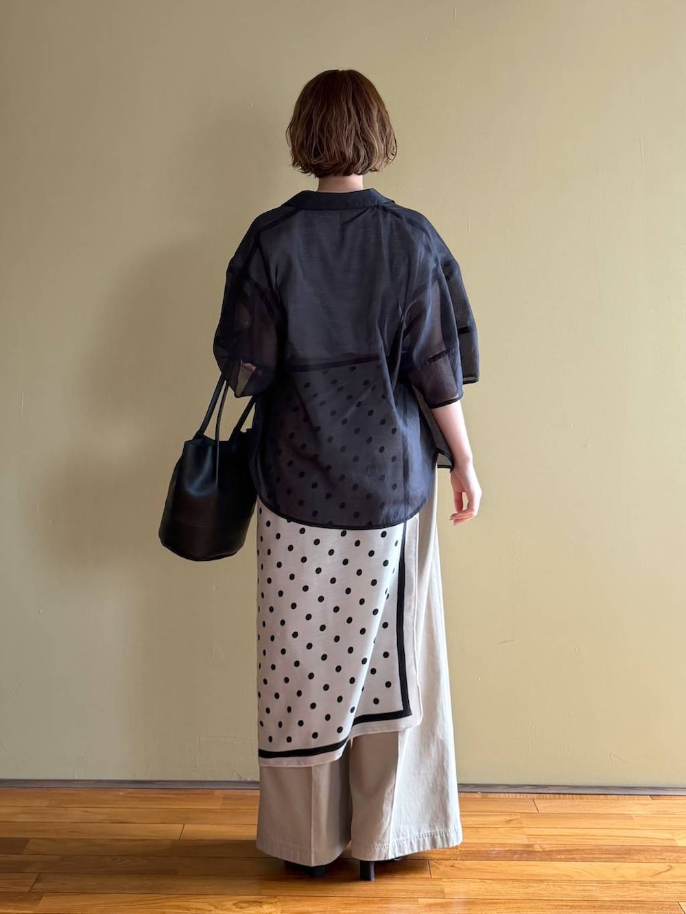 ブラック系のサンダル、ブラック系のシャツ/ブラウス、ベージュ系のチノパンツを着用したレディースの春コーディネートの3枚目の写真