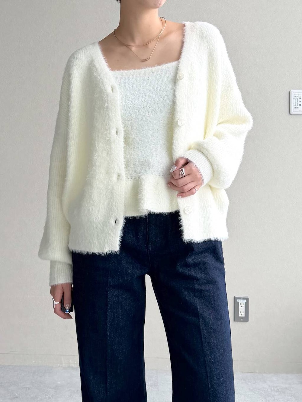 ブルー系のデニムパンツ、ホワイト系のカーディガン/ボレロ、ブラック系のボストンバッグを着用したレディースの秋コーディネートの8枚目の写真