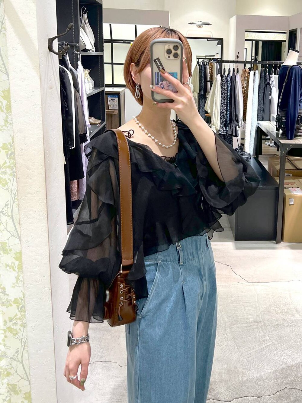 ブラック系のパンプス、ブルー系のデニムパンツ、ブラック系のシャツ/ブラウスを着用したレディースの春コーディネートの4枚目の写真