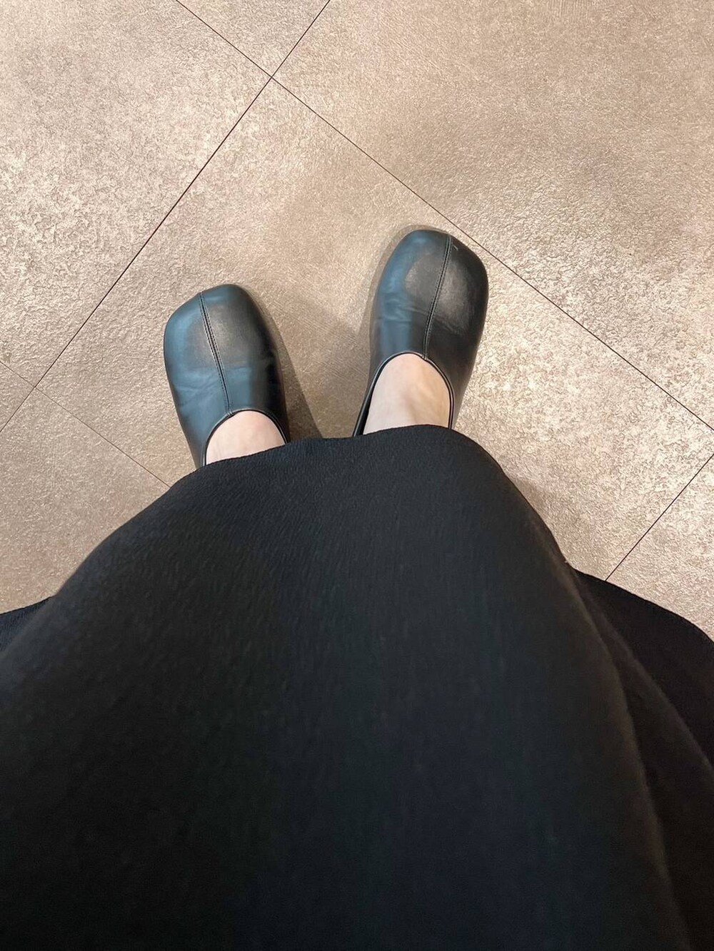 ブラック系のトートバッグ、ホワイト系のシャツ/ブラウス、ブラック系のパンプスを着用したレディースの春コーディネートの6枚目の写真