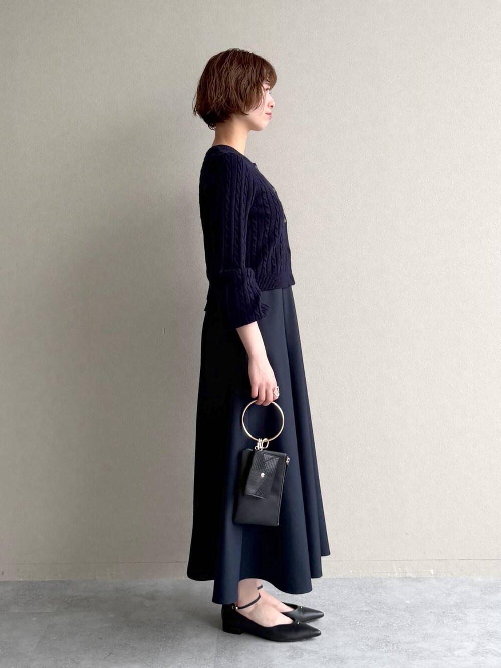 ブルー系のワンピース、ブラック系のパンプス、ブラック系のショルダーバッグを着用したレディースの冬コーディネートの2枚目の写真