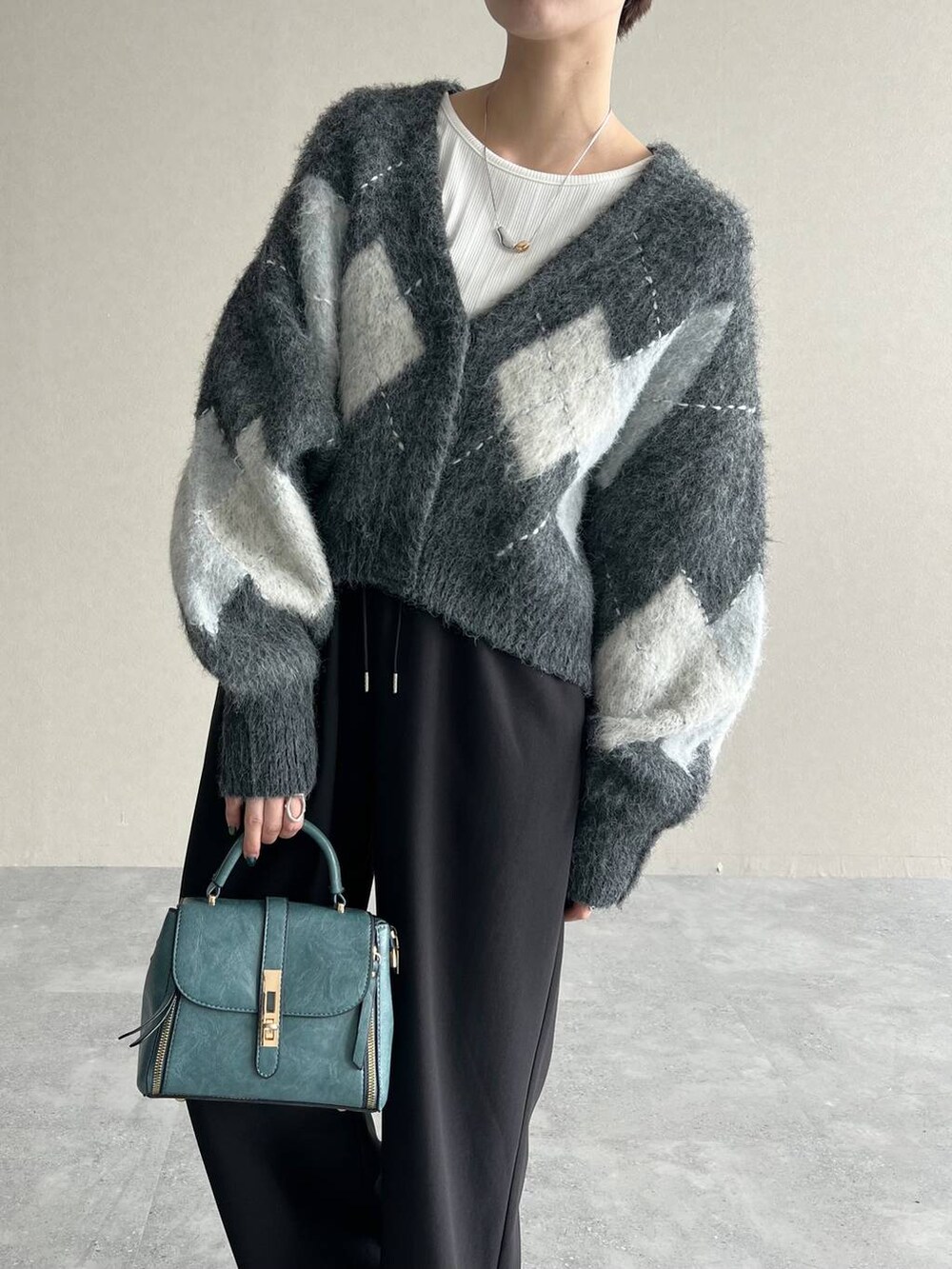 グレー系のカーディガン/ボレロ、ホワイト系のTシャツ/カットソー、ブラック系のローファーを着用したレディースの秋コーディネートの4枚目の写真