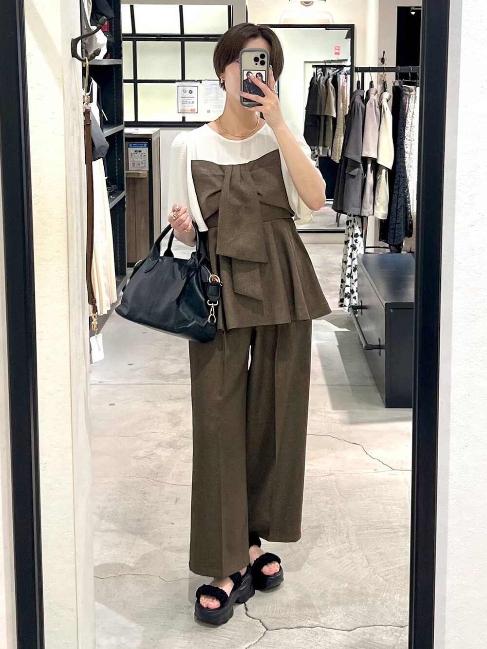 ブラック系のサンダル、ブラック系のボストンバッグ、ブラウン系のその他パンツを着用したレディースの夏コーディネートの4枚目の写真