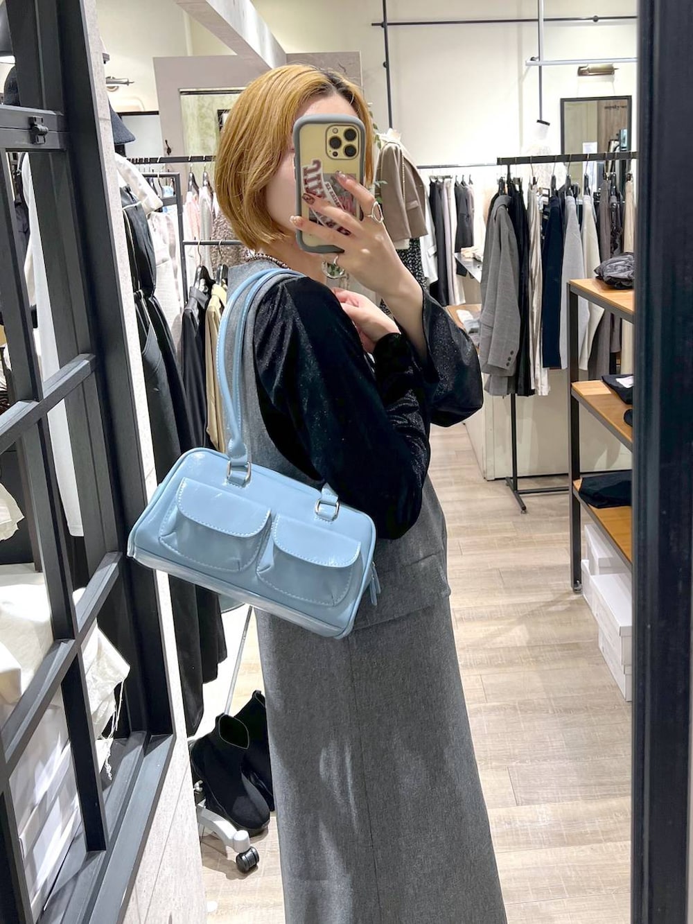 ブラック系のブルゾン、ブラック系のブーツ、グレー系のジャンパースカートを着用したレディースの秋コーディネートの9枚目の写真