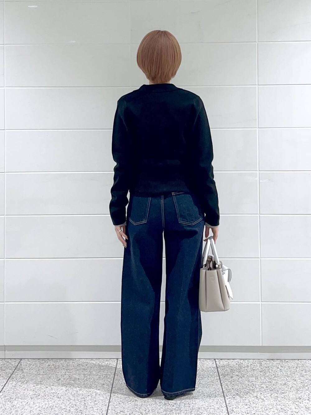 ブルー系のデニムパンツ、ベージュ系のショルダーバッグ、ブラック系のバレエシューズを着用したレディースの春コーディネートの3枚目の写真