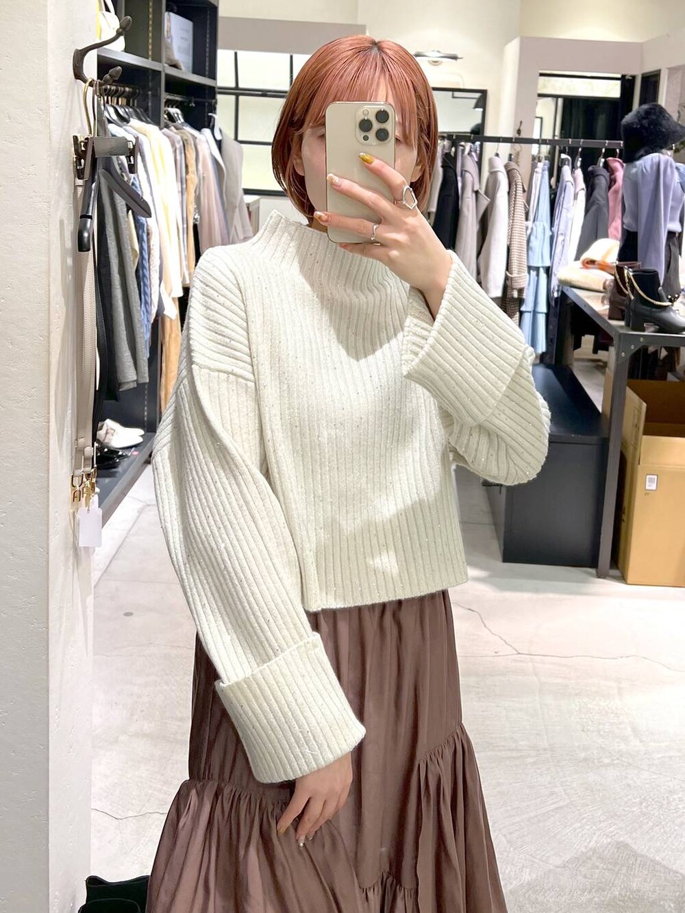 ブラック系のボストンバッグ、ブラック系のブーツ、ブラウン系のスカートを着用したレディースの冬コーディネートの4枚目の写真