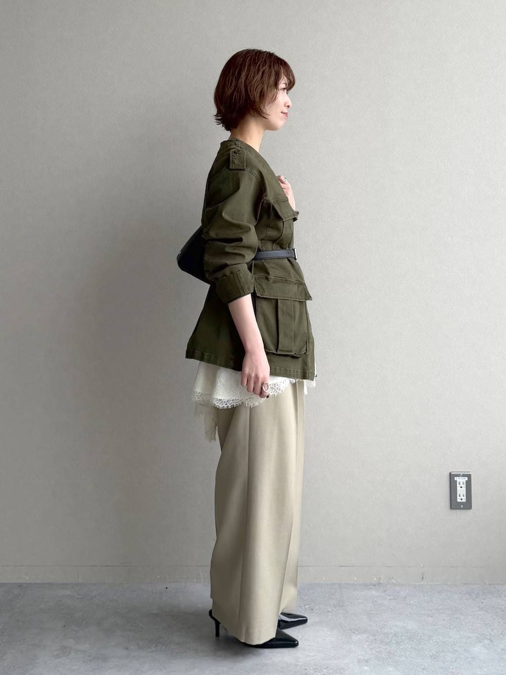 ホワイト系のTシャツ/カットソー、ベージュ系のその他パンツ、ブラック系のサンダルを着用したレディースの冬コーディネートの2枚目の写真