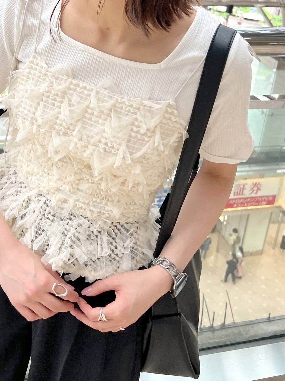 ブラック系のサンダル、ブラック系のスラックス、ブラック系のショルダーバッグを着用したレディースの春コーディネートの5枚目の写真