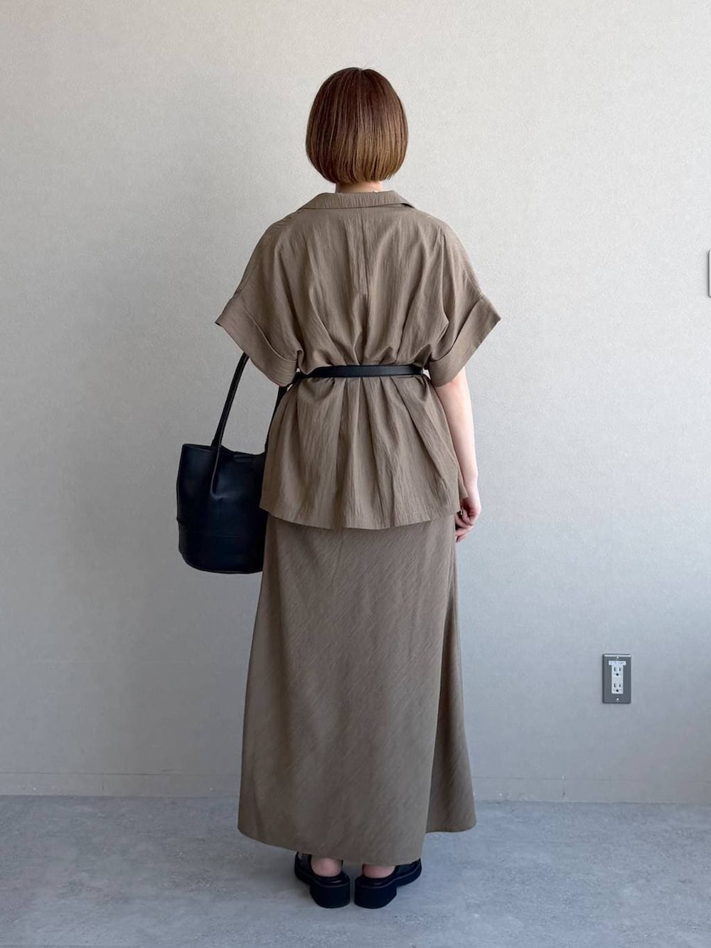 ブラック系のサンダル、ブラック系のTシャツ/カットソー、ブラウン系のスカートを着用したレディースの春コーディネートの3枚目の写真