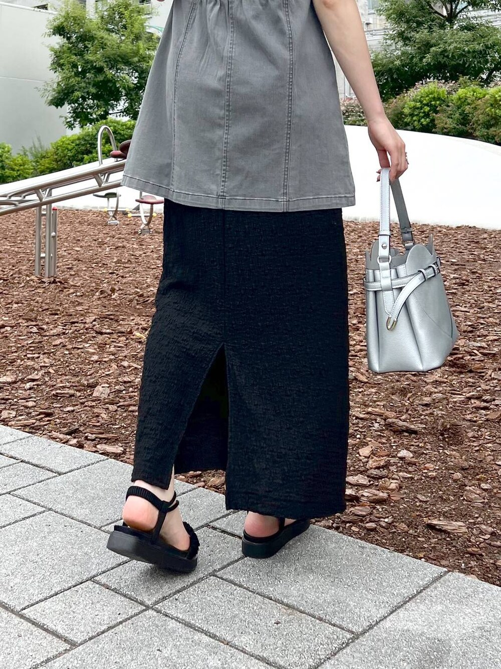 ブラック系のサンダル、ブラック系のベスト、ブラック系のニット/セーターを着用したレディースの夏コーディネートの6枚目の写真