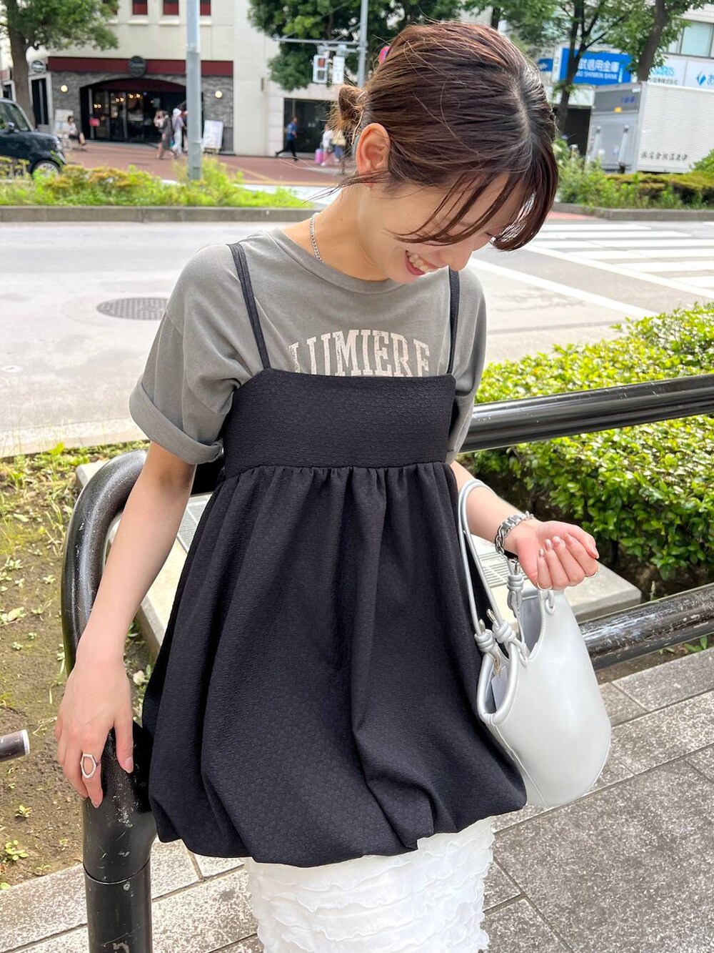 ブラック系のサンダル、シルバー系のハンドバッグ、ホワイト系のスカートを着用したレディースの夏コーディネートの3枚目の写真
